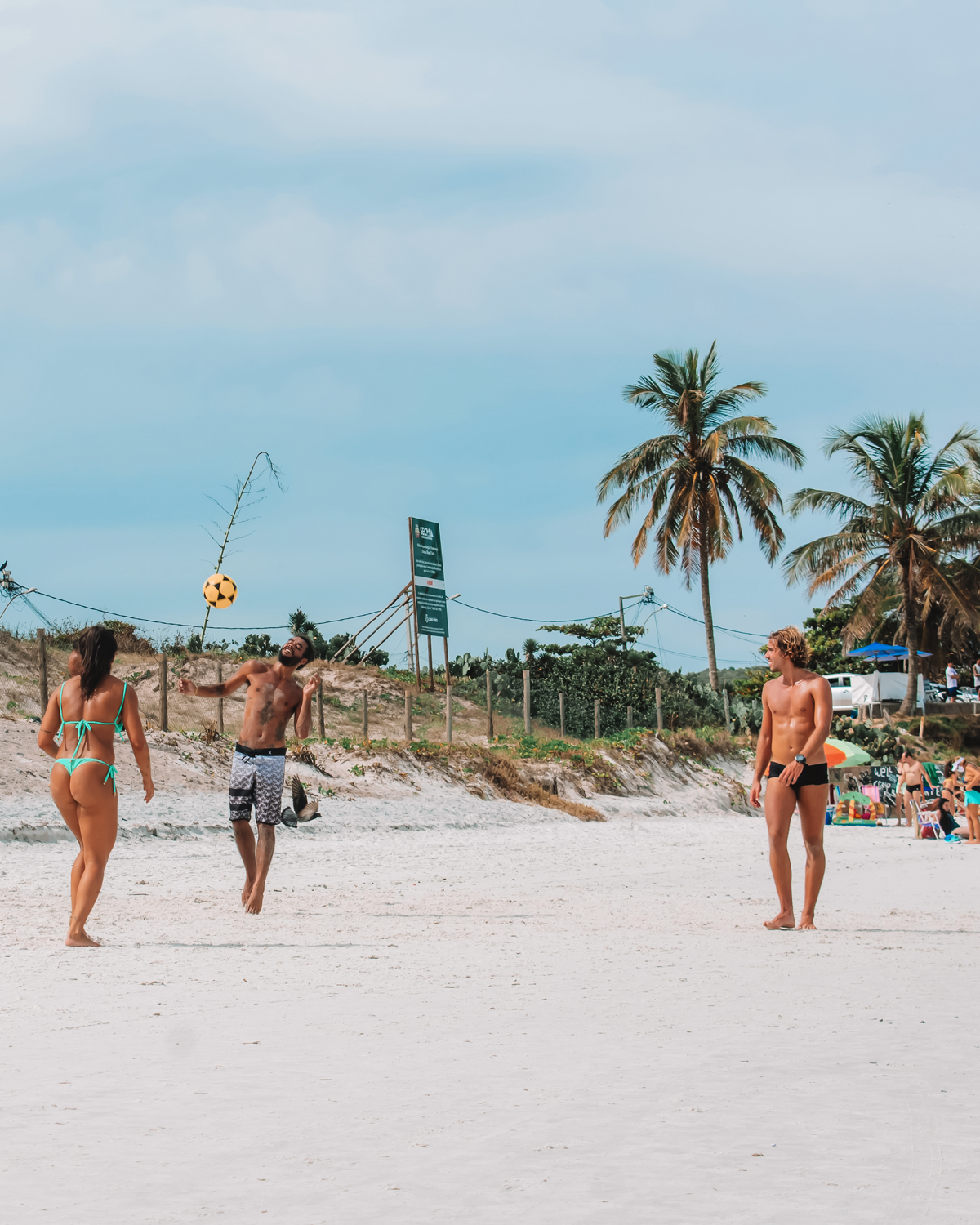 A group of young people playing soccer on Praia do Forte in Cabo Frio, reflecting the outdoor lifestyle and recreational activities available on the coast.